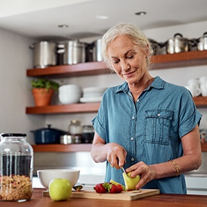 Woman smiling while preparing snack in kitchen